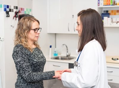 Doctor holding patient's hands, helping and empathy concept.